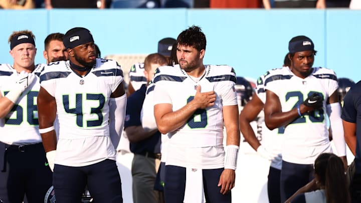 Aug 17, 2024; Nashville, Tennessee, USA; Seattle Seahawks quarterback Sam Howell (6), linebacker Devin Richardson (43), cornerback Nehemiah Pritchett (28), and teammates stand for the National Anthem before the game against the Tennessee Titans at Nissan Stadium. 
