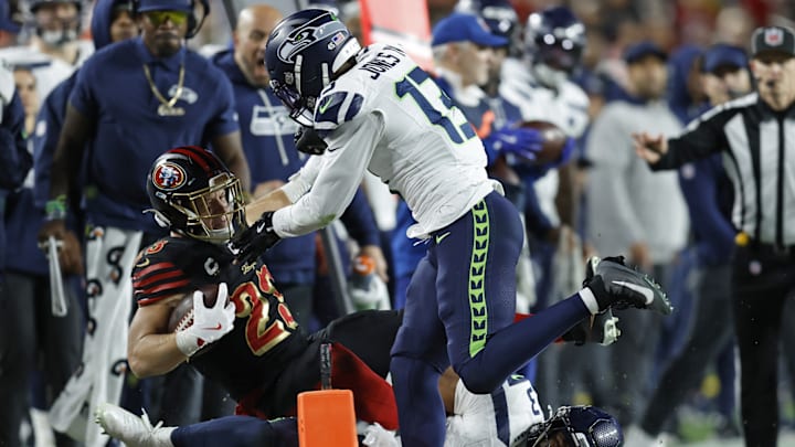 Jan 3, 2026; Santa Clara, California, USA; Seattle Seahawks linebacker Ernest Jones IV (13) tackles San Francisco 49ers running back Christian McCaffrey (23) during the first half at Levi's Stadium.