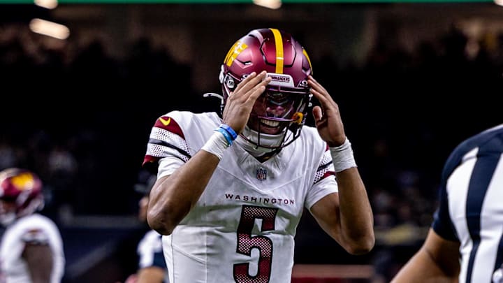 Dec 15, 2024; New Orleans, Louisiana, USA;  Washington Commanders quarterback Jayden Daniels (5) reacts to throwing a touchdown to wide receiver Terry McLaurin (17) against the New Orleans Saints during the first half at Caesars Superdome. Mandatory Credit: Stephen Lew-Imagn Images