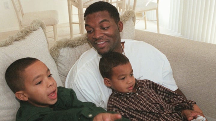 Suns center Oliver Miller plays with his boys Amman (in lap), 4, and Xavier, 8, in his Phoenix home in 1999.