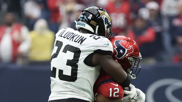 Nov 26, 2023; Houston, Texas, USA; Houston Texans wide receiver Nico Collins (12) is tackled by Jacksonville Jaguars linebacker Foyesade Oluokun (23) in the second half at NRG Stadium. Mandatory Credit: Thomas Shea-Imagn Images