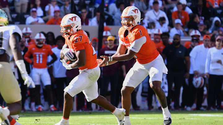 Oct 4, 2025; Blacksburg, Virginia, USA;  Virginia Tech Hokies quarterback Kyron Drones (1) hands the ball to running back Marcellous Hawkins (27) against the Wake Forest Demon Deacons during the third quarter at Lane Stadium. Mandatory Credit: Brian Bishop-Imagn Images