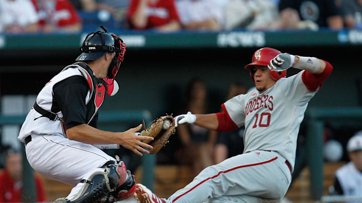 Jun 15, 2013; Omaha, NE, USA; Indiana Hoosiers runner Kyle Schwarber (10) is tagged out in the third inning by the Louisville Cardinals catcher Shane Crain (41) during the College World Series game at TD Ameritrade Park. Jun 15, 2013; Omaha, NE, USA; Indiana Hoosiers runner Kyle Schwarber (10) is tagged out in the third inning by the Louisville Cardinals catcher Shane Crain (41) during the College World Series game at TD Ameritrade Park.