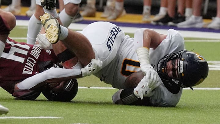 Regina's tight end Tate Wallace (0) gets tackle by Grundy Center's wide receiver/defensive back Eli Wegmann (4) after making a catch for a first down during the second quarter in the 1A High School state semi-final on Nov. 14, 2025, at UNI-Dome in Cedar Falls, Iowa.