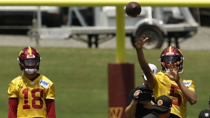 Jun 10, 2025; Ashburn, VA, USA; Washington Commanders quarterback Jayden Daniels (5) passes the ball as Commanders quarterback Marcus Mariota (18) looks on during drills on day one of minicamp at Commanders Park. Mandatory Credit: Geoff Burke-Imagn Images
