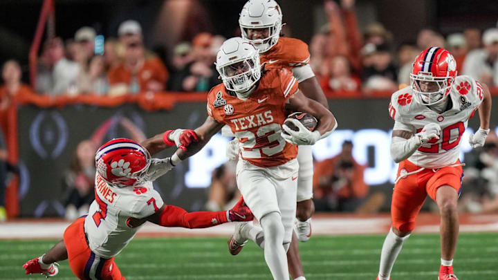 Texas running back Jaydon Blue stiff-arms Clemson safety Khalil Barnes.