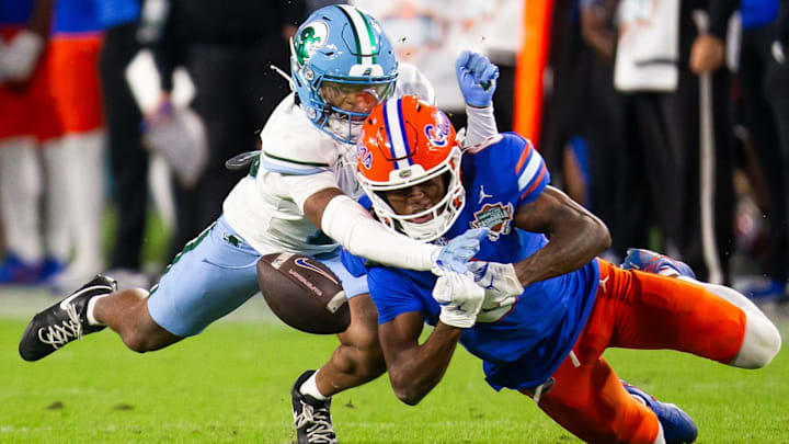 Tulane Green Wave safety Javion White (12) breaks up a pass intended for Florida Gators wide receiver Elijhah Badger (6) during the second half at Raymond James Stadium in Tampa, FL on Friday, December 20, 2024 in the 2024 Union Home Mortgage Gasparilla Bowl. The Gators defeated Tulane 33-8. [Doug Engle/Gainesville Sun]