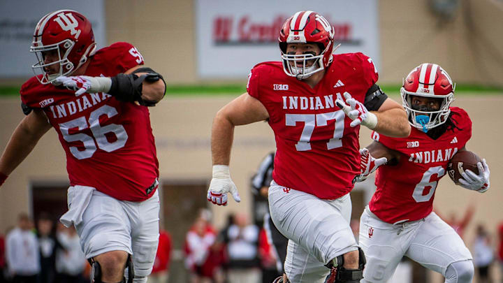 Indiana's Justice Ellison (6) runs behind Tyler Stephens (77) and Mike Katic (56) against Michigan at Memorial Stadium.