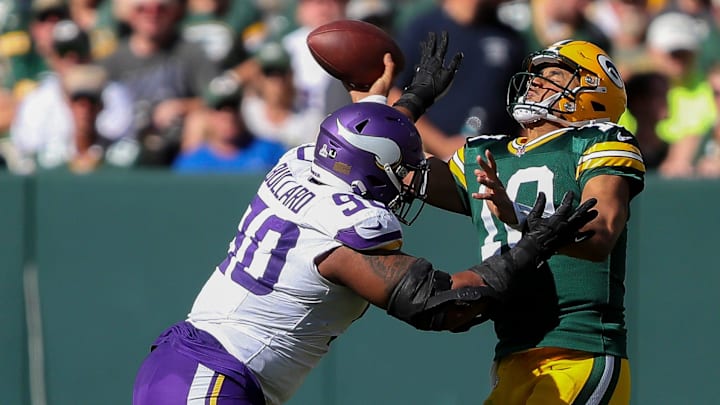 Green Bay Packers quarterback Jordan Love throws the ball under pressure from Minnesota Vikings defensive end Jonathan Bullard.