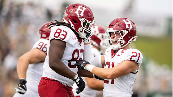 Harvard defensive lineman Christian Nwosu (83) and safety Ty Bartrum (21)