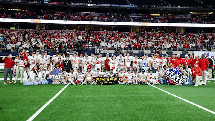 Colmubus coaches and players pose for a team shot following their victory in the Texas 3A Division 1 title game at AT&T Stadium.