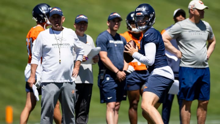 Denver Broncos coaches Sean Payton, Pete Carmichael, and Joe Lombardi observe quarterback Zach Wilson passing during OTAs. 