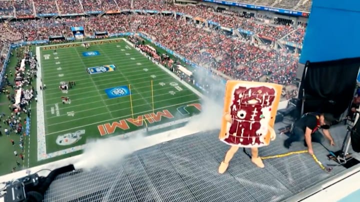 The 2023 Pop-Tarts Bowl mascot celebrates atop Camping World Stadium.