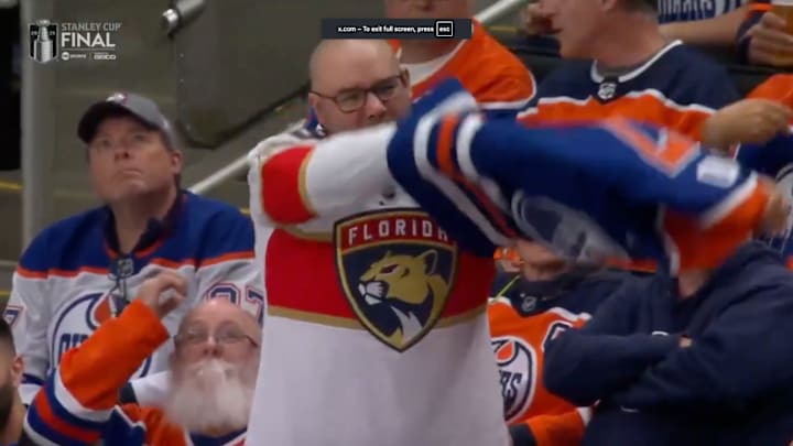 A fan at Game 5 of the Stanley Cup Final takes off his Oilers jersey to reveal a Panthers jersey. A fan at Game 5 of the Stanley Cup Final takes off his Oilers jersey to reveal a Panthers jersey.