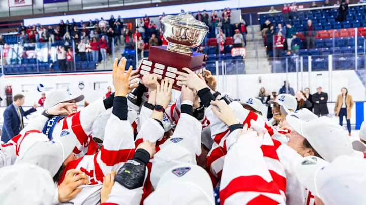 Boston University lift the Hockey East championship trophy after winning the tournament in 2025.