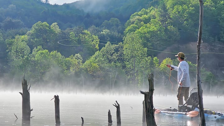 Fly angler and West Virginia guide Chase McCoy, throwing a tight loop while balanced on his kayak. 