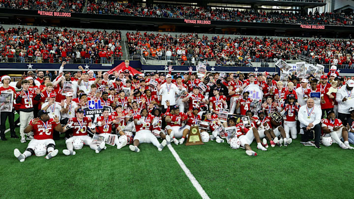 Carthage coaches and players pose for a team shot following their victory in the Texas 4A Division 2 state championship game at  AT&T Stadium.