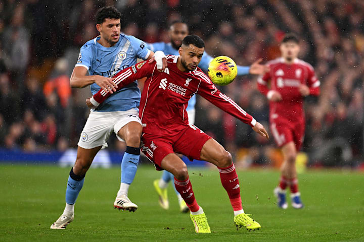 Cody Gakpo (middle) leaning against Matheus Nunes.