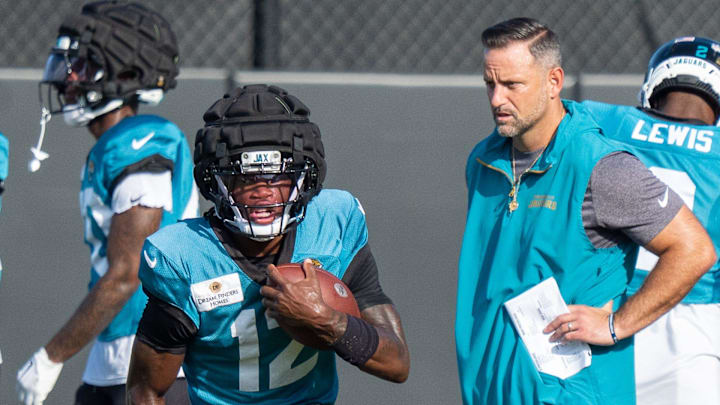 Jacksonville Jaguars wide receiver Travis Hunter (12) runs a drill as Jacksonville Jaguars Defensive Coordinator Anthony Campanile watches during the Jaguars 14th NFL training camp session at Miller Electric Center Tuesday August 12, 2025 in Jacksonville, Fla. The Jaguars travel to New Orleans to play the Saints this Sunday in their second preseason game. [Doug Engle/Florida Times-Union]