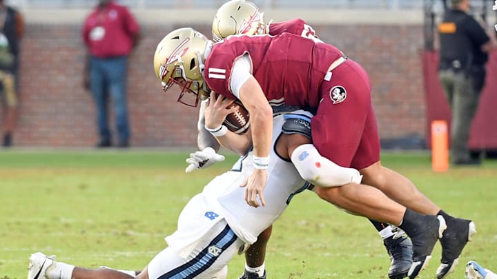 Nov 2, 2024; Tallahassee, Florida, USA;  Florida State Seminoes quarterback Brock Glenn (11) is sacked by the North Carolina Tarheels defense in the fourth quarter at Doak S. Campbell Stadium. Mandatory Credit: Robert Myers-Imagn Images
