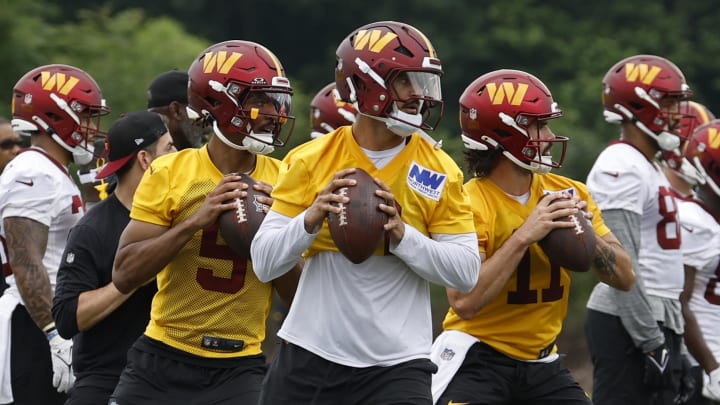 Jun 5, 2024; Ashburn, VA, USA; Washington Commanders quarterback Jayden Daniels (5), Commanders quarterback Marcus Mariota (0), and Commanders quarterback Sam Hartman (11) prepare to pass a ball during OTA workouts at Commanders Park. Mandatory Credit: Geoff Burke-USA TODAY Sports