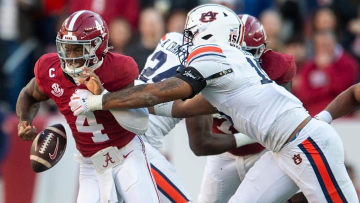 Alabama Crimson Tide quarterback Jalen Milroe (4) fumbles the ball while pressured by Auburn Tigers defensive lineman Keldric Faulk (15) as Auburn Tigers take on Alabama Crimson Tide at Bryant-Denny Stadium in Tuscaloosa, Ala., on Saturday, Nov. 30, 2024. Alabama Crimson Tide leads Auburn Tigers 14-6 at halftime.