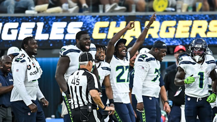 Aug 10, 2024; Inglewood, California, USA; Seattle Seahawks cornerback Riq Woolen (27) and other teammates react from the sidelines after a play against the Los Angeles Chargers during the fourth quarter at SoFi Stadium. 