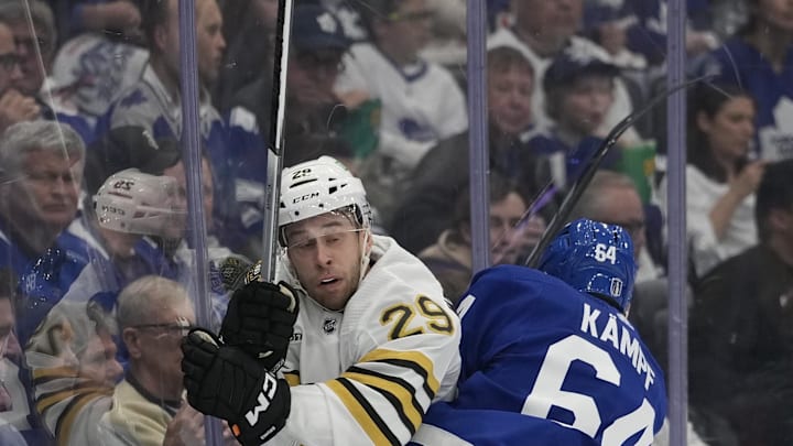 Apr 24, 2024; Toronto, Ontario, CAN; Toronto Maple Leafs forward David Kampf (64) checks Boston Bruins defenseman Parker Wotherspoon (29) into the boards during the first period of game three of the first round of the 2024 Stanley Cup Playoffs at Scotiabank Arena. Mandatory Credit: John E. Sokolowski-USA TODAY Sports