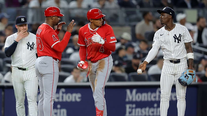 Jun 16, 2025; Bronx, New York, USA; New York Yankees third baseman Jazz Chisholm Jr. (13) takes the ball out of play after Los Angeles Angels second baseman Christian Moore (4) triples during the eighth inning at Yankee Stadium. The triple was his first major league hit. 