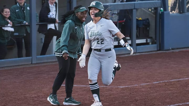 Michigan State's Britain Beshears high-fived head coach Shoronda McDonald-Kelley after hitting a home run against Michigan.