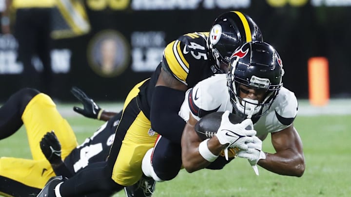Aug 9, 2024; Pittsburgh, Pennsylvania, USA;  Houston Texans wide receiver Johnny Johnson III (front) dives for additional yardage as Pittsburgh Steelers linebacker Jacoby Windmon (45) defends during the fourth quarter at Acrisure Stadium. Houston won 20-12. Mandatory Credit: Charles LeClaire-Imagn Images