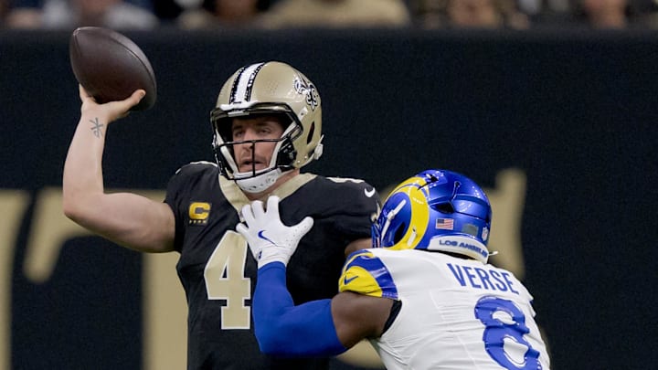 Dec 1, 2024; New Orleans, Louisiana, USA; New Orleans Saints quarterback Derek Carr (4) throws against Los Angeles Rams linebacker Jared Verse (8) during the first half at Caesars Superdome. Mandatory Credit: Matthew Hinton-Imagn Images