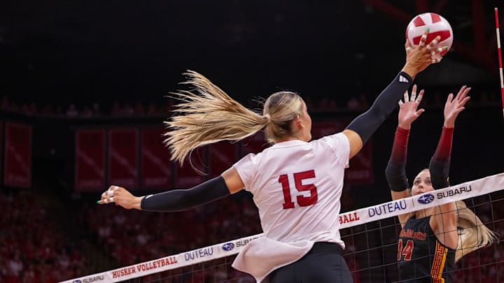 Nebraska middle blocker Andi Jackson (15) hits a ball over USC outside hitter Ally Batenhorst.
