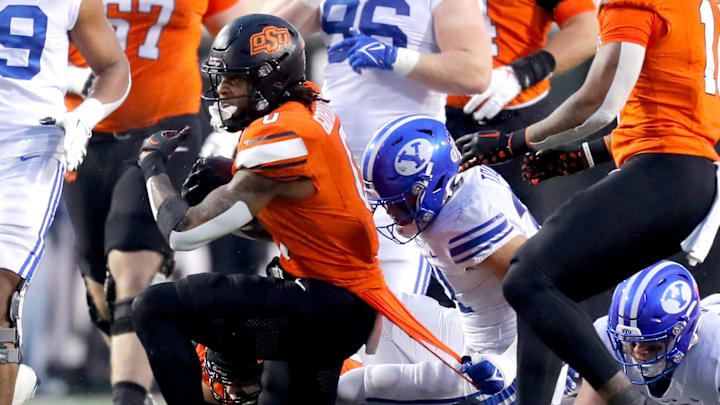 BYU's Max Tooley (31) pulls the shirt of Oklahoma State's Ollie Gordon II (0) in the second half of the college football game between the Oklahoma State University Cowboys and the Brigham Young Cougars at Boone Pickens Stadium in Stillwater, Okla., Saturday, Nov. 25, 2023. BYU's Max Tooley (31) pulls the shirt of Oklahoma State's Ollie Gordon II (0) in the second half of the college football game between the Oklahoma State University Cowboys and the Brigham Young Cougars at Boone Pickens Stadium in Stillwater, Okla., Saturday, Nov. 25, 2023.
