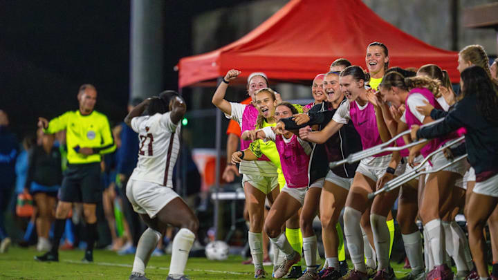 Taylor Lewin flexes in front of her teammates. 