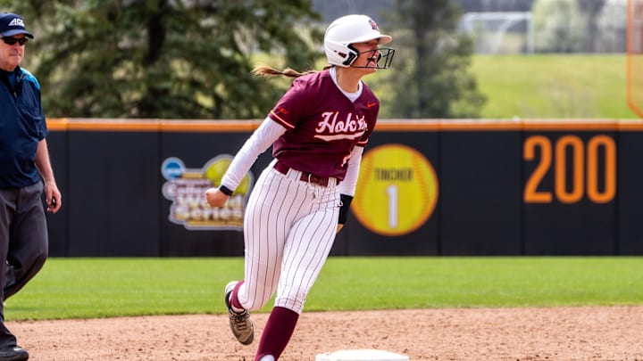 Kylie Aldridge rounds second base celebrating after hitting a home run. 
