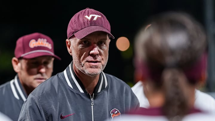 Tech head coach Pete D'Amour talks to his players during a meeting.