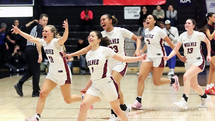 The Tualatin girls basketball team celebrates the first OSAA Class 6A state championship in program history.