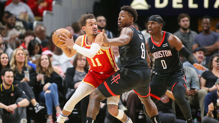 Feb 10, 2024; Atlanta, Georgia, USA; Atlanta Hawks guard Trae Young (11) is defended by Houston Rockets forward Jae'Sean Tate (8) and guard Aaron Holiday (0) in the second half at State Farm Arena. Mandatory Credit: Brett Davis-Imagn Images
