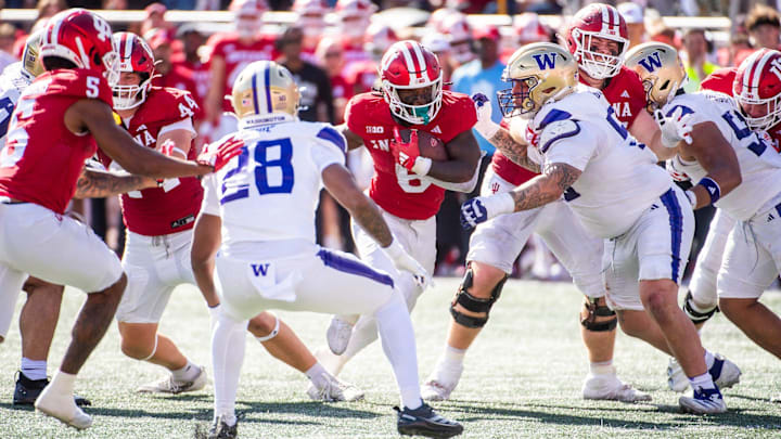 The UW's Khmori House and Jacob Bandes (55) converge on Indiana running back Justice Ellison (6).