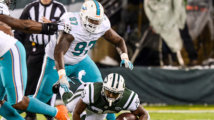Miami Dolphins defensive tackle Jordan Phillips (97) tackles New York Jets running back Bilal Powell (29) during the game between the New York Jets and the Miami Dolphins at MetLife Stadium in a 2016 game.