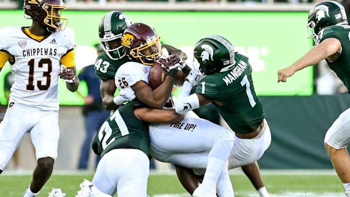 Michigan State's Dillon Tatum, left, Malik Spencer and Jaden Mangham tackle Central Michigan's Myles