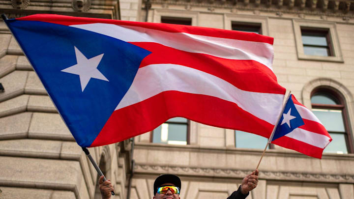 Tony Rivera of Worcester waves flags during a rally for Puerto Rico at City Hall Wednesday.