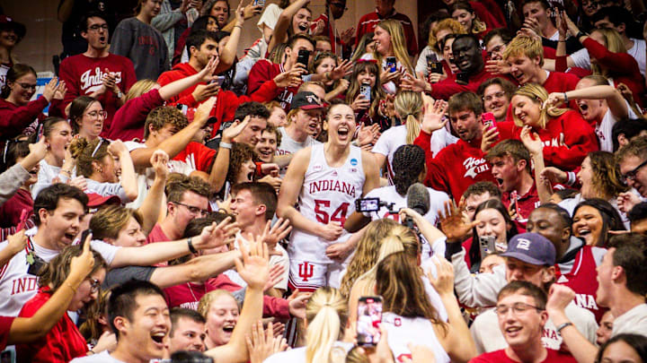 Indiana's Mackenzie Holmes (54) celebrates in the stands with fans after second-round NCAA women's