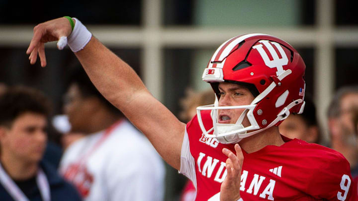 Indiana's Kurtis Rourke (9) gets loose before the start of the Indiana versus Michigan football game at Memorial Stadium on Friday, Nov. 9, 2024.