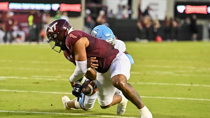 Sep 13, 2025; Blacksburg, Virginia, USA;  Old Dominion Monarchs linebacker Jeremy Mack Jr. (4) strips the ball from Virginia Tech Hokies quarterback Kyron Drones (1) during the first quarter at Lane Stadium. Mandatory Credit: Brian Bishop-Imagn Images