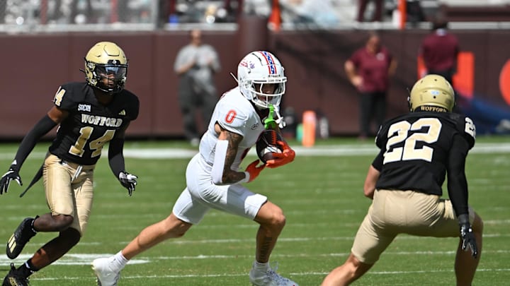 Sep 20, 2025; Blacksburg, Virginia, USA; Virginia Tech Hokies wide receiver Ayden Greene (0) runs after a catch as Wofford Terriers defensive back Darius Malcolm Jr. (14) and defensive back Perrin Ketchin (22) pursue during the third quarter at Lane Stadium. Mandatory Credit: Brian Bishop-Imagn Images