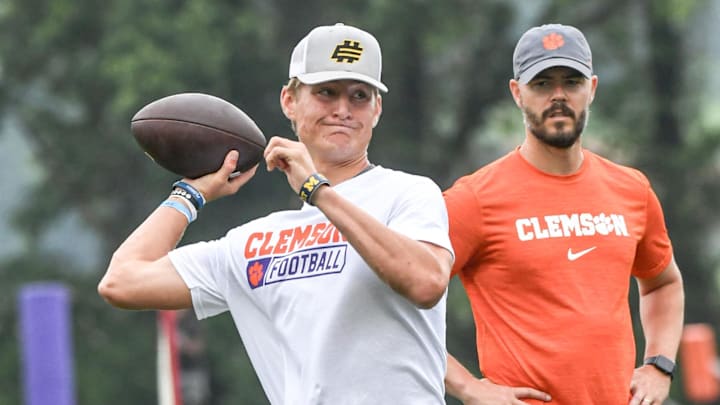 Brady Hart, left, of Cocoa Florida passes near Clemson offensive coordinator Garrett Riley during the 2024 Dabo Swinney Football Camp in Clemson in Clemson June 5, 2024.