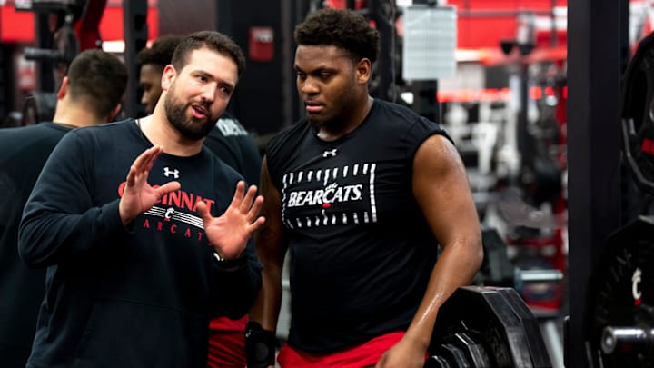 Cincinnati Bearcats Football Sports Performance director Niko Palazeti speaks with Cincinnati Bearcats defensive lineman Dominique Perry during a weight lifting session on at The Lindner Center in Cincinnati on Thursday, Feb. 9, 2023.

Ncaa Basketball Portrait Photos For Niko Palazeti Profile