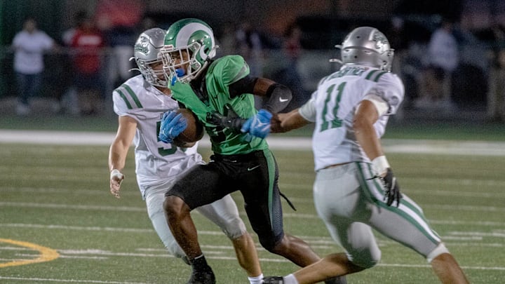St. Mary’s Kenneth Moore III, center, threads his way between De La Salle’s Lukas Platzbecker, left, and Ant Dean during a varsity football game at St. Mary’s in Stockton on Sep. 20, 2024.